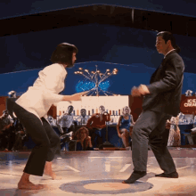 a man and a woman are dancing on a dance floor in front of a sign that says ice cream