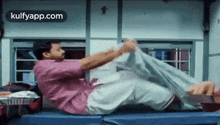 a man is doing exercises on a train while sitting on a bed .