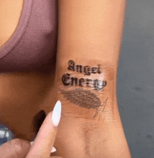 a woman has a tattoo on her wrist that says angel energy