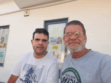 two men standing in front of a building with one wearing a shirt that says ' define 2altera '