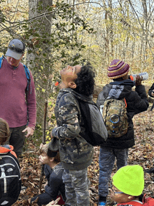 a man in a pink shirt is talking to a group of kids