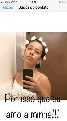 a woman taking a picture of herself with flowers in her hair