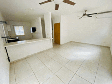 an empty room with a ceiling fan in the middle