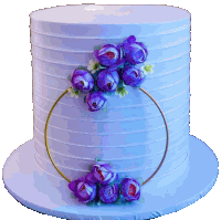 a white cake with purple flowers and a gold ring around it