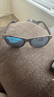 a pair of sunglasses laying on top of a brown pillow