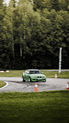 a green car is driving on a track with a license plate that says ' jct ' on it