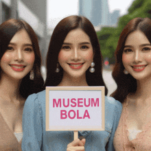 a woman holds a sign that says museum bola