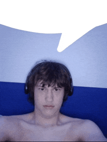 a shirtless man wearing headphones looks at the camera with a speech bubble above his head