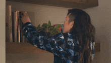 a woman is reaching for a book on a shelf with a book titled " a brief history of humans " on it