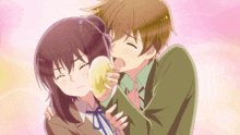 a boy kisses a girl on the cheek while holding a yellow object