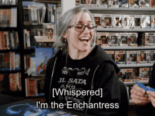 a woman wearing a black shirt that says i 'm the enchantress is laughing