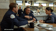 a group of firefighters sitting around a table with a #chicagofire hashtag