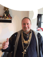 a man wearing a necklace that says dmcs giving a thumbs up