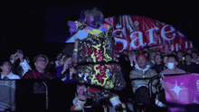 a wrestler stands in front of a crowd in front of a sign that says ' free ' on it