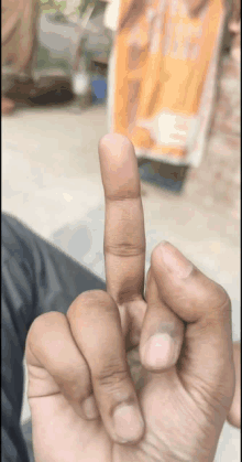 a close up of a person 's hand making a middle finger gesture