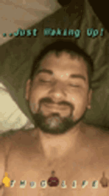 a shirtless man with a beard is laying on a bed with his eyes closed .