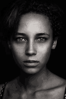 a black and white photo of a young woman with freckles