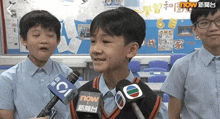 a boy is talking into a microphone with a now logo on it