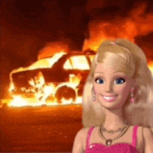 a barbie doll is smiling in front of a burning car .