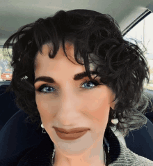 a woman with curly hair is smiling for the camera