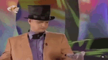 a man in a top hat and bow tie is holding a toy .
