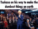 a man in a blue suit is standing in front of a crowd of people with the caption tsubasa on his way