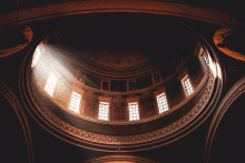 looking up at the dome of a building with lots of windows