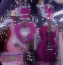 a pink guitar with a heart shaped headstock is on display