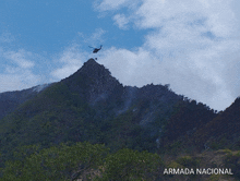 a picture of a helicopter flying over a mountain with the words armada nacional below it