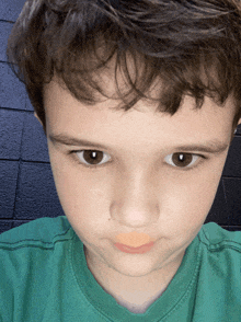 a close up of a child 's face with a green shirt on