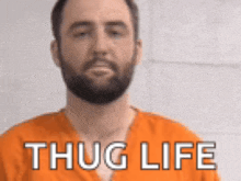 a man with a beard is wearing an orange jumpsuit with the words thug life written on it