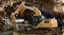 a yellow excavator is driving through a cave .