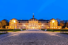 a large building with a statue on top of it is lit up at night