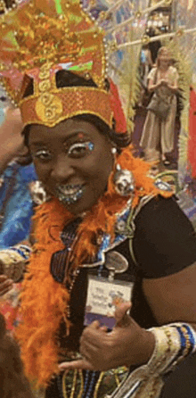 a woman wearing a carnival costume is giving a thumbs up