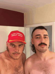 two men are posing for a picture and one has a make america great again hat on