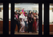 a group of women are standing in front of a sign that says ' a ' on it