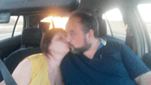 a man and woman kissing in a car with the word airbag on the rear view mirror