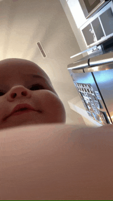 a baby 's face is visible in front of a refrigerator