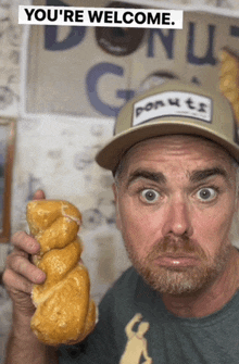 a man wearing a donuts hat holds a donut in his hand