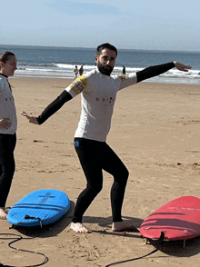 a man wearing a quiksilver shirt is standing on the beach