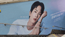 a billboard of a young man with the name jin-iusi on it