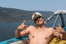 a shirtless man in a captain 's hat is laying on a boat