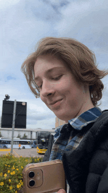 a young man is holding a cell phone in his right hand