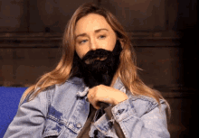 a woman wearing a fake beard and denim jacket