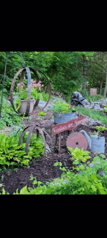 a garden with a wheelbarrow , a sign that says `` families are forever '' and a sign that says `` families are forever ''