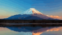 mount fuji is reflected in the water of a lake .