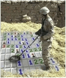 a man in a military uniform is using a metal detector to find numbers on a board .