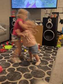 two little girls dancing in front of a tv