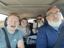 a man wearing an adidas shirt is sitting in the back of a car