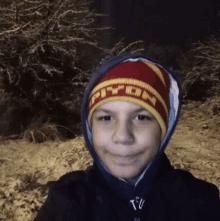 a young boy wearing a hoodie and a hat that says ' tfu ' on it